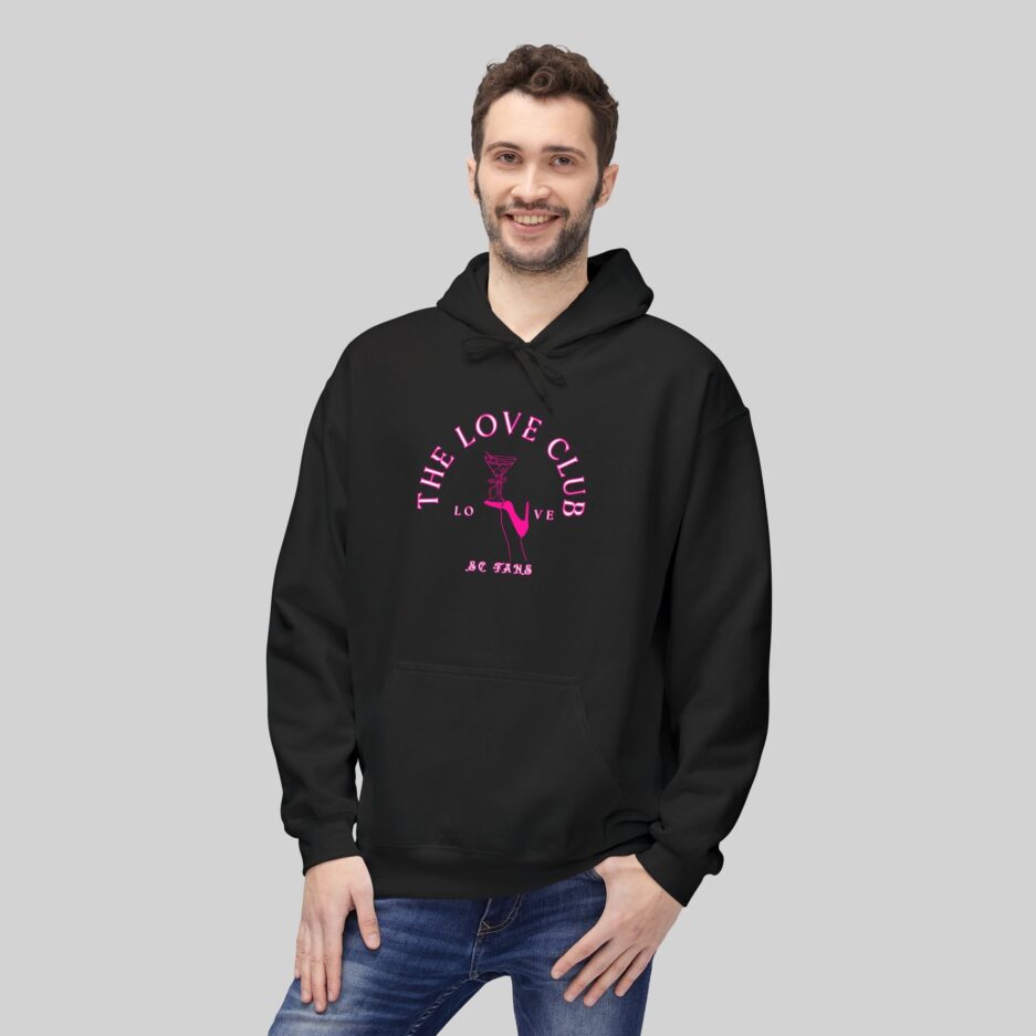 Man wearing a black Sabrina Carpenter Love Club Hoodie with pink text on a gray background