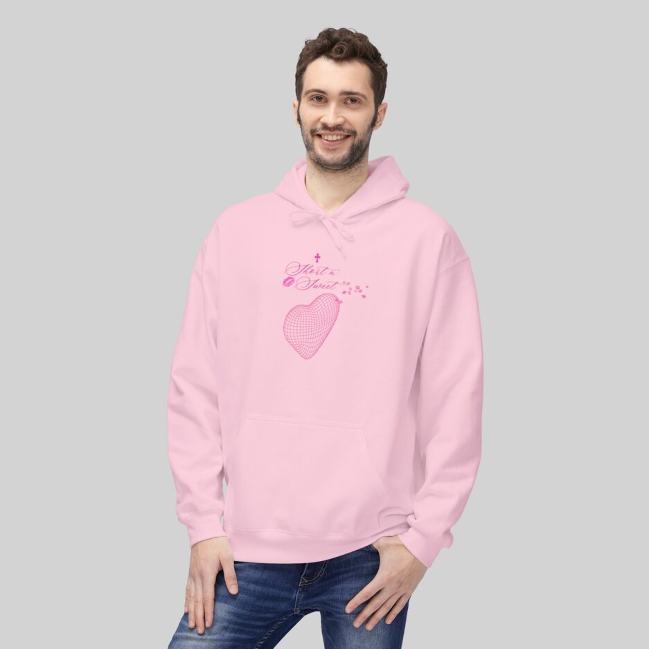 Man wearing a pink Sabrina Carpenter Short n' Sweet Hoodie with a heart design on a light gray background